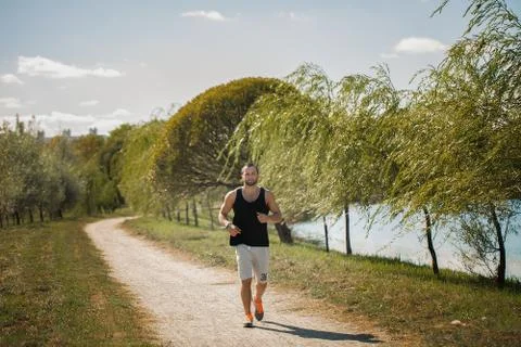 Energetic young man do exercises outdoors in park to keep their Stock Photos