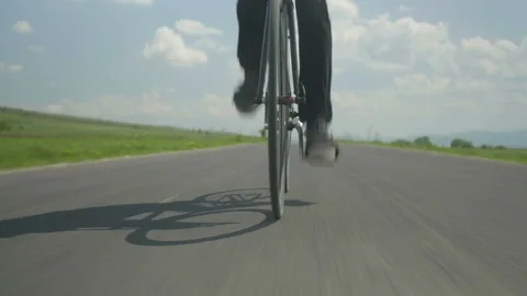 Energetic young man with moustache riding a bike fast along the road 4k Stock Footage 85557706