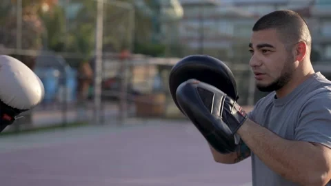 Energizing Morning Routine: Guy's Shadowboxing on Palm-Fringed Basketball Court Stock Footage 243170403