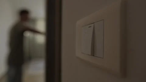 Energy conservation at home, close up of light switch as man turns off lights in Stock Footage 346243732