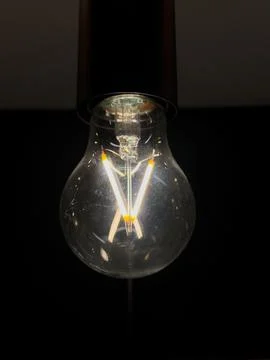 Energy-efficient lamp glowing in a dark setting Stock Photos