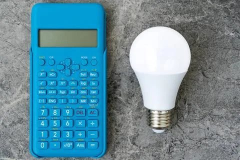 Energy efficient light bulb and blue modern calculator Energy efficient li... Stock Photos