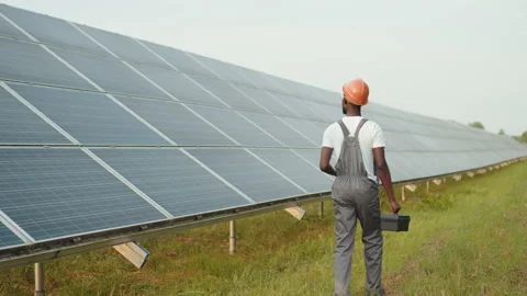 Energy engineer with instruments walking on solar farm. Back view of african Stock Footage 168592373