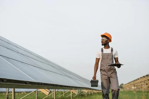 Energy engineer with instruments walking on solar farm Foto stock