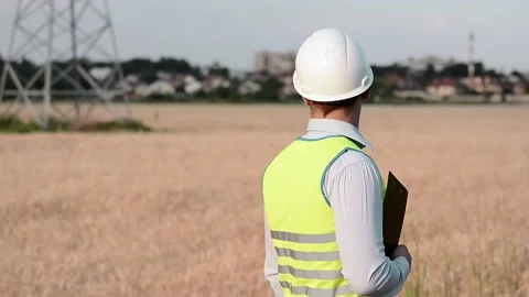 An energy engineer in special clothes inspects a power line using data from elec Stock Footage 202652207