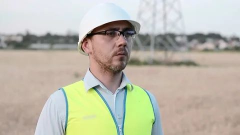 An energy engineer in special clothes inspects a power line using data from elec Vídeo Stock 202652292