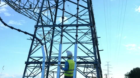 Energy engineer with tablet, white helmet, and reflective vest inspects an Stock Footage 281061519