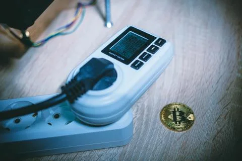 Energy meter next to coin bitcoin Stock Photos