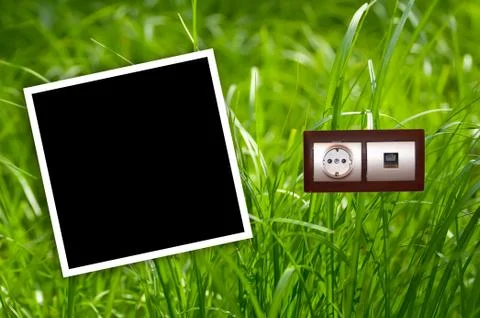 Energy outlet in grass with empty frames.environment concept. Stock-Fotos