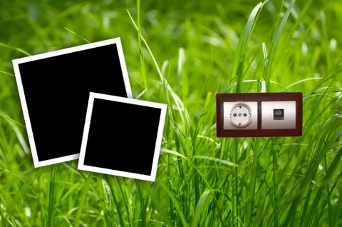 Energy outlet in grass with empty frames.environment concept. Stock Photos