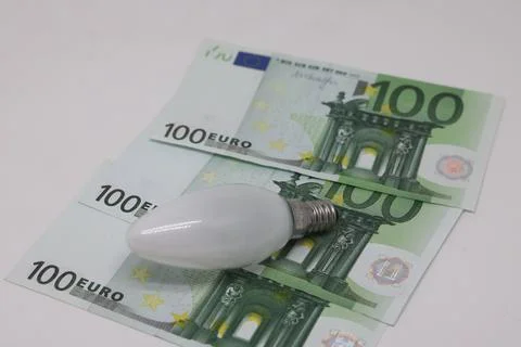 Energy saving bulb on dollars Stock Photos