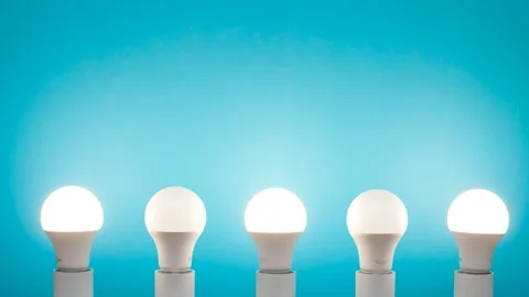 Energy saving bulbs flash white like a strobe on a blue background. Stock Footage 144211159