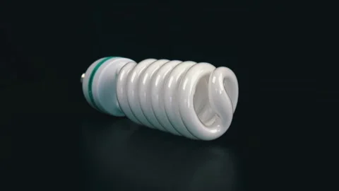 Energy saving fluorescent light bulb on black table Stock Footage 105745235