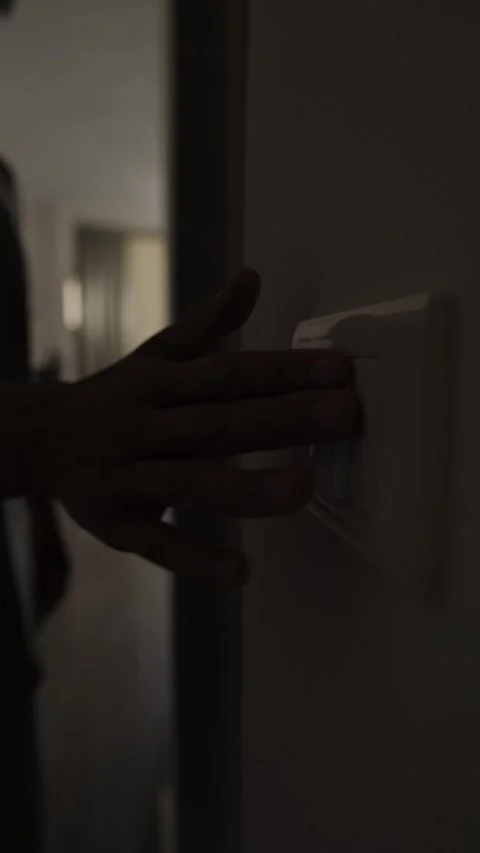 Energy saving habit at home, close up of light switch as man remembers to turn Stock Footage 346243815