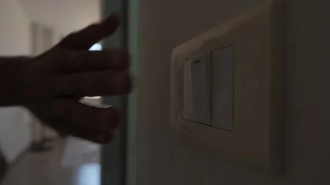 Energy saving habit at home, close up of light switch as man remembers to turn Stock Footage 346243920
