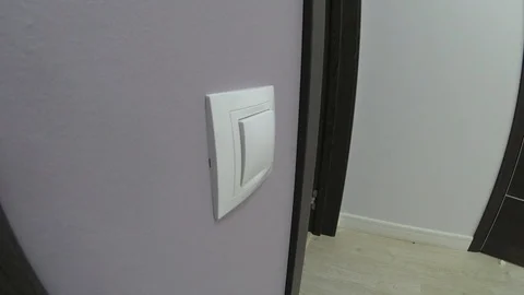 Energy saving - hand turning off a light switch in a house 스톡 동영상 92968429