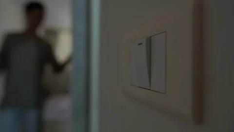 Energy saving at home, close up of light switch as man turns off lights to save Stock Footage 346243753