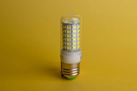 Energy saving LED light bulb on a yellow background with empty space Stock Photos