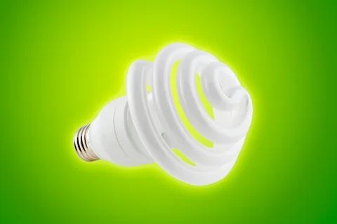 Energy saving light bulb on green background Stock Photos