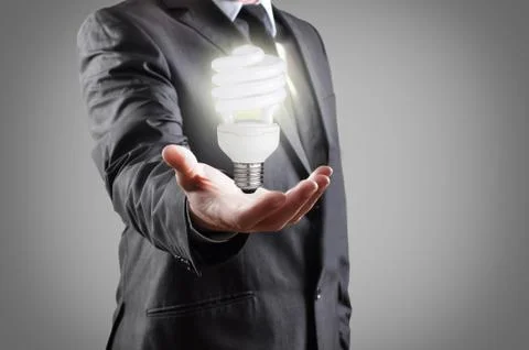 Energy saving light bulb in hand of businessman Stock Photos