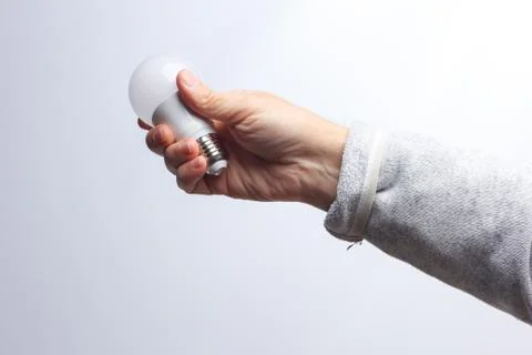 Energy saving light bulb in the hand of an adult Stock Photos