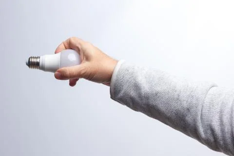 Energy saving light bulb in the hand of an adult Stock Photos