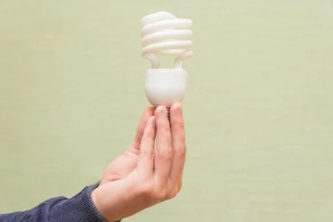 Energy saving light bulb in the hands of a man Stock Photos