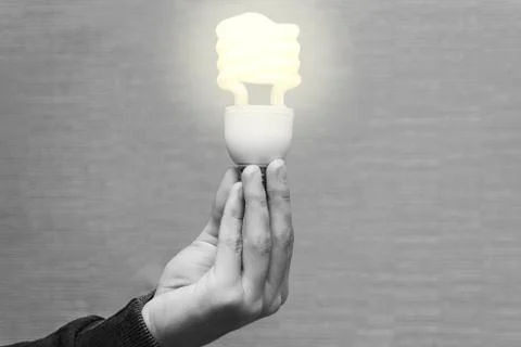 Energy saving light bulb in the hands of a man Stock Photos