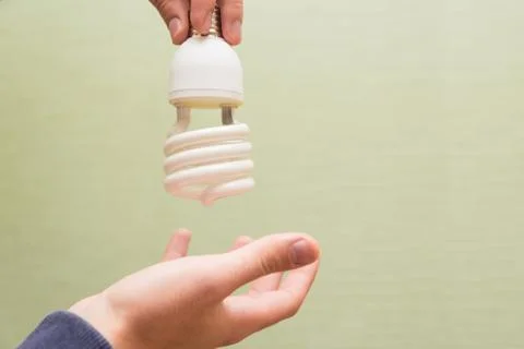 Energy saving light bulb in the hands of a man Stock Photos