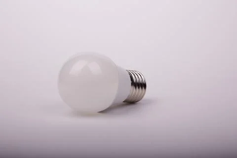 Energy-saving light bulb on a light gray background Stock Photos
