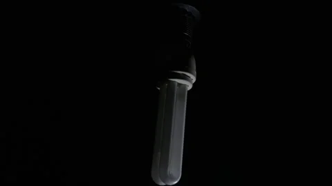 Energy Saving Light Bulb Silhouette with Dramatic Low Key Studio Lighting Stock Footage 334136873