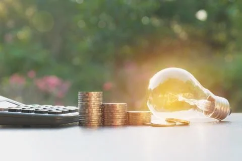 Energy saving light bulb with stacks of coins and calculator for financial, a Stock Photos