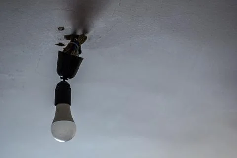 Energy-saving light bulb under the ceiling Stock Photos