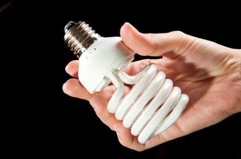 Energy saving lightbulb in hand Stock Photos