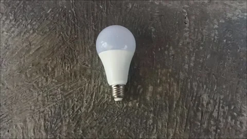 Energy Saving White LED Light Bulb on Dark Stone Texture Background Stock Footage 333878957