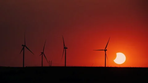 Energy transition concept, solar eclipse sunset over wind turbines time lapse Stock Footage 343561455