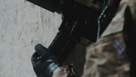 Enforcer loading the magazine to an automatic rifle during the war operation Stock Footage 171141719