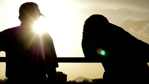Engaged conversation between elder and younger man, against a warm sky. Stock Footage 289519670