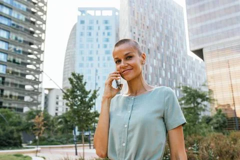 Engaged in Conversation: Urban Professional Using Smartphone Amidst City Stock Photos