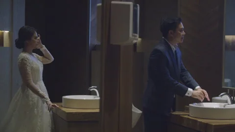 Engaged Couple Looking at the Mirrors in a Luxury Restroom Stock Footage 334021246