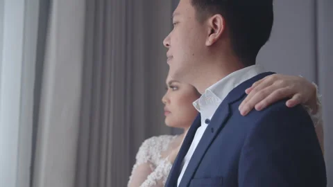 Engaged Couple Looking Out Hotel Window and Embracing Stock Footage 334026683
