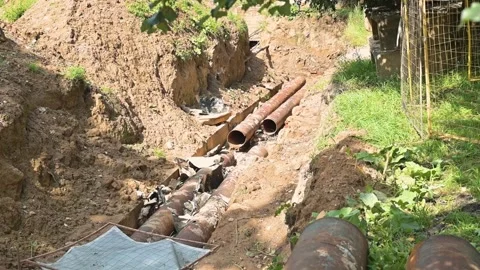 Engaged in digging and installing large pipes at a construction site outdoors. Stock-Footage 345884466