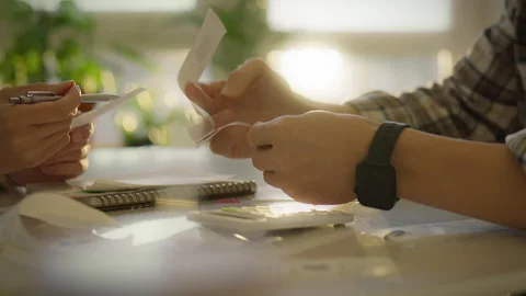 Engaged in financial planning with receipts and a calculator at a cozy works Stock Footage 303661863
