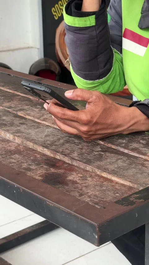 Engaged Individual Navigates Digital World with Smartphone on Rustic Table .. 스톡 동영상 325234762