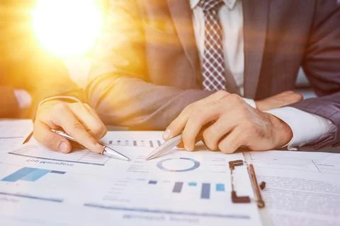 Engaged professional colleagues sit at table and predict profit Foto stock