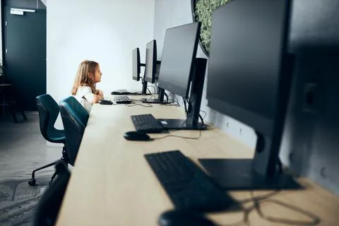 Engaged schoolgirl learning to use technology in classroom at primary schoo.. Stock Photos