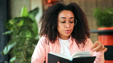 Engaged Woman Reading and Explaining from a Book in a Modern Environment. Stock-Footage 313518249