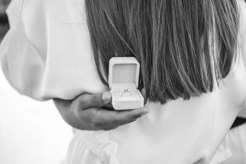 Engaged woman's hands with a diamond ring on her partner's shoulders 库存照片