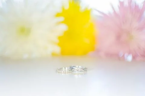 Engagement and wedding ring on white flower background Stock Photos
