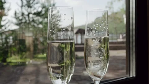 Engagement rings fall in champagne. Two wine glasses with champagne bubbles Stock Footage 130421306